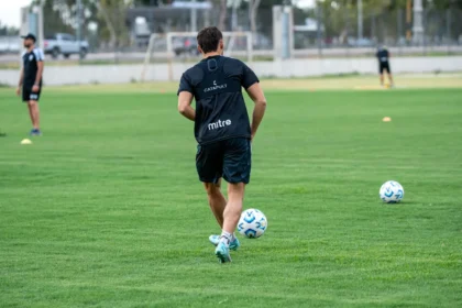 Calciatore in allenamento prepara il pallone sul campo prima della partita