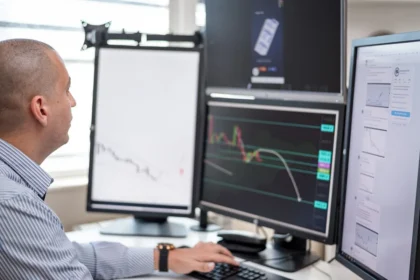 Trader monitora grafici in rialzo sui mercati azionari in una sala operativa finanziaria