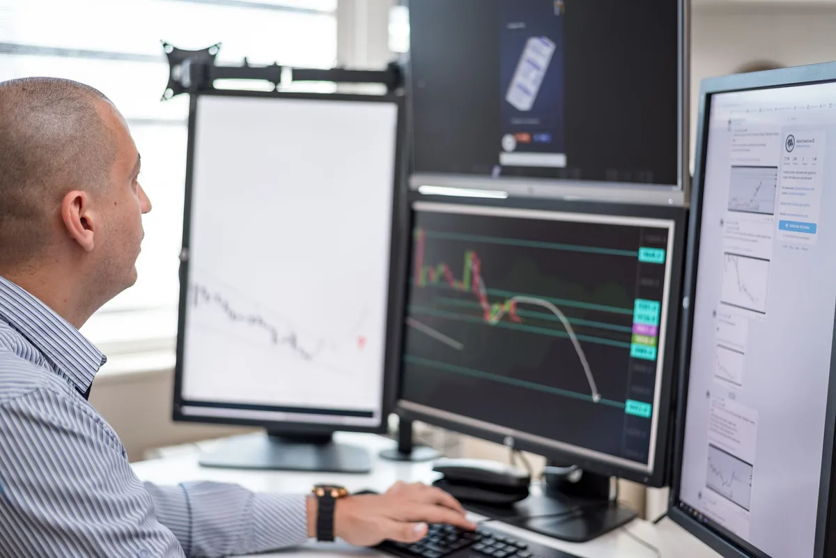 Trader monitora grafici in rialzo sui mercati azionari in una sala operativa finanziaria