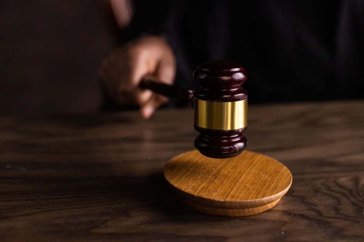 Aula di tribunale con sentenza e documenti giudiziari che riconoscono le responsabilit&agrave; legali