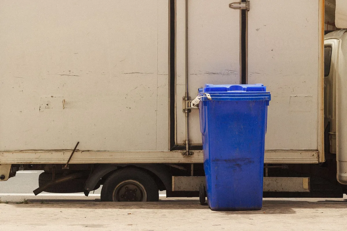 Camion di raccolta rifiuti in azione durante la pulizia urbana