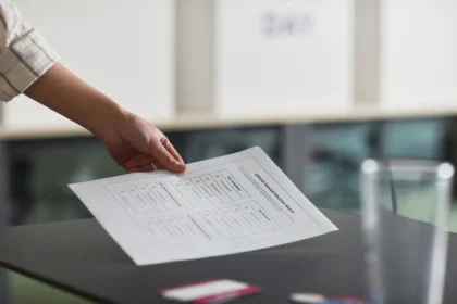 Mano che inserisce una scheda di voto in un'urna durante una consultazione elettorale