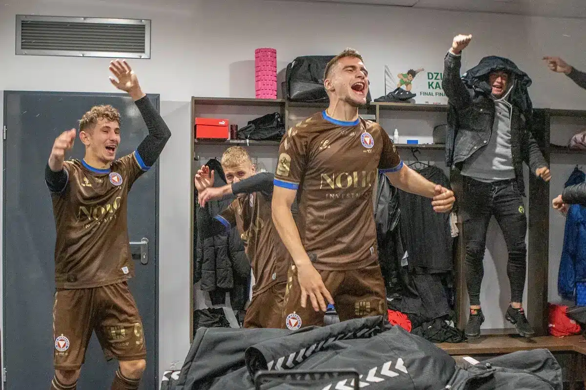 Spogliatoio con panchina e scarpe da calcio, simbolo di esperienza in squadra