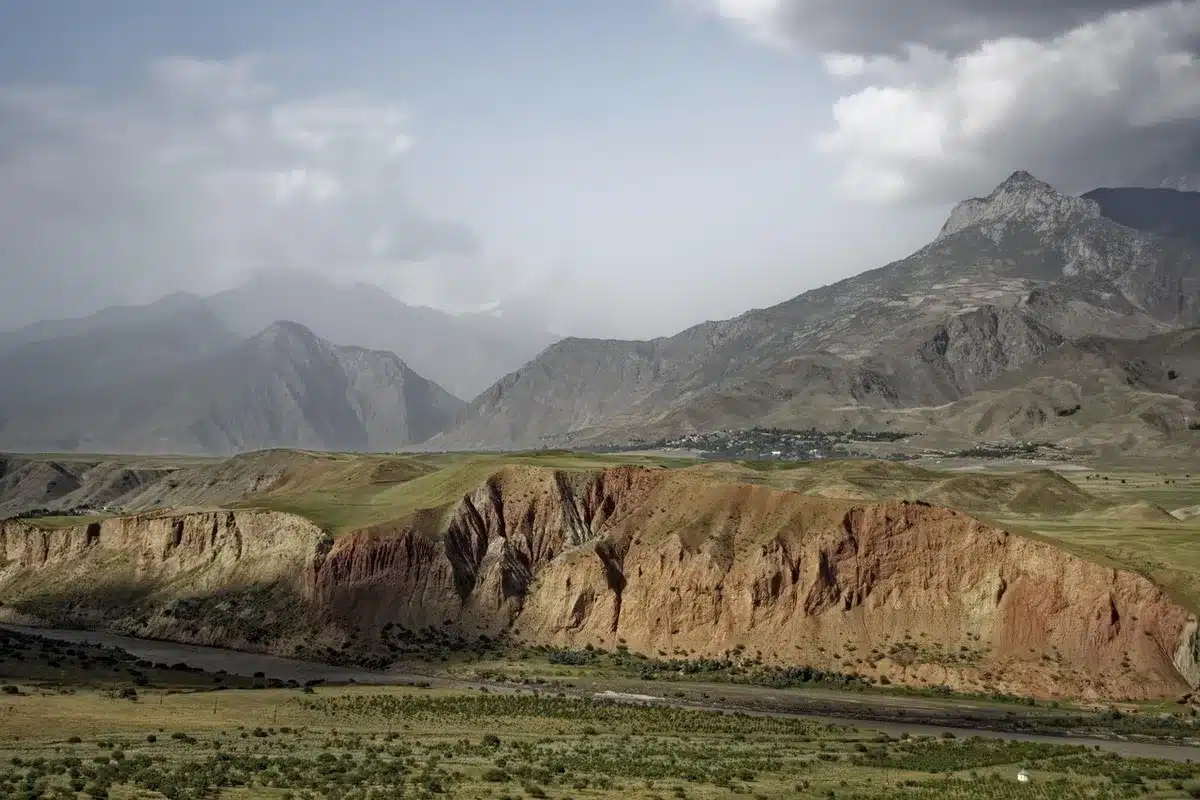 Presidio anonimo su strada di montagna con cartelli e persone di spalle