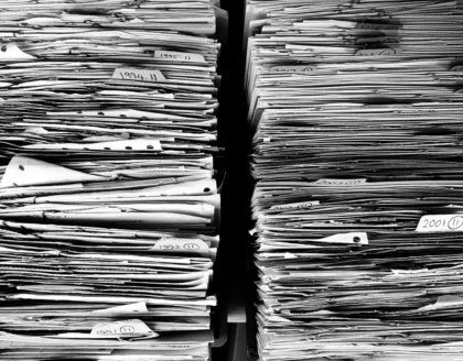 Facciata anonima di edificio istituzionale con folder e documenti su un tavolo