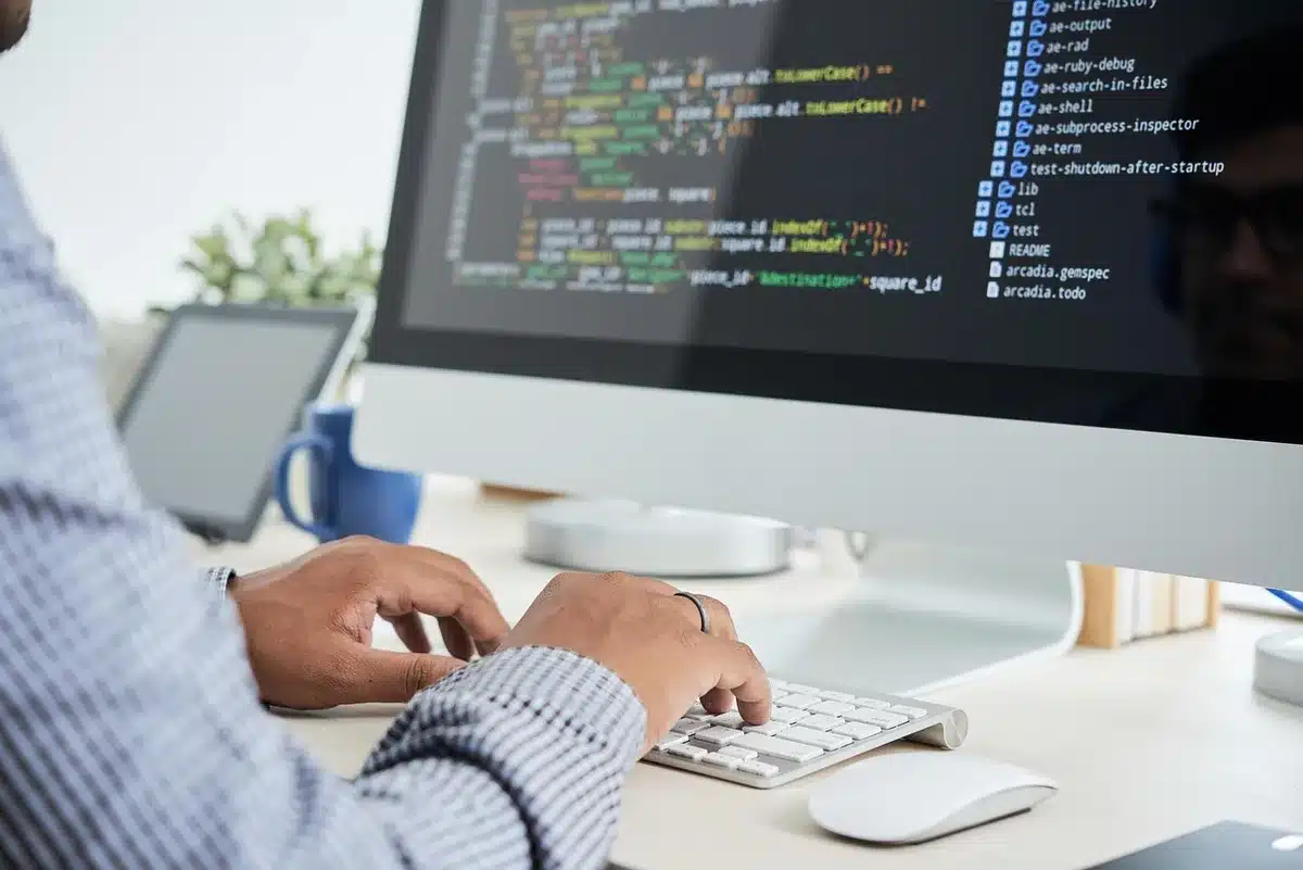 Schermo con interfaccia software e persone che testano caricamenti massivi