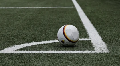 Tifosi anonimi in gradinata con sciarpe e palloni in uno stadio locale