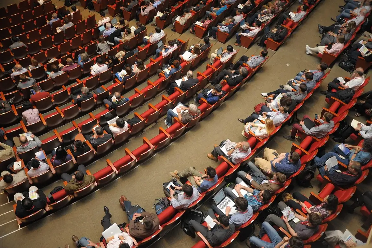 Partecipanti anonimi a dibattito in una sala della Casa del Popolo
